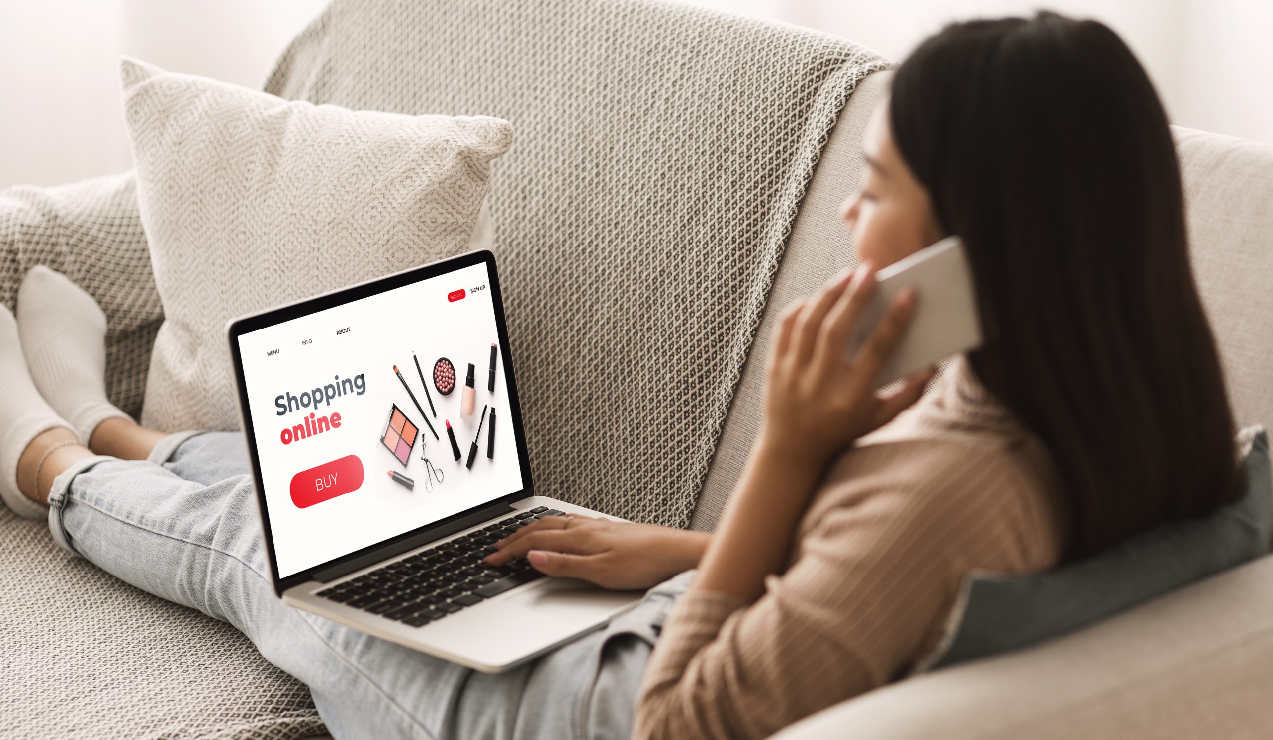 Female Shopping Concept. Back view of woman browsing online make up store, talking on phone, sitting at home. Online Beauty Stores in Canada. Nail supplies. nail stores. Best nail stores.
