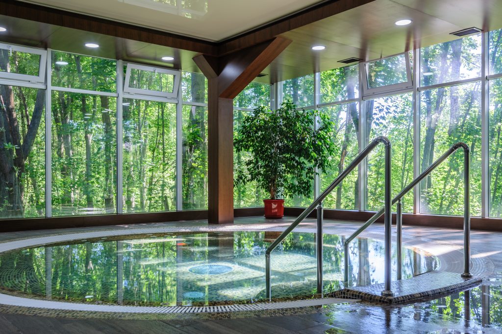 Big luxury hot thub in hotel spa green area, copyspace