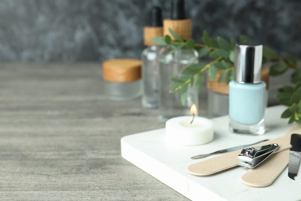 Concept of nail care with manicure accessories on gray wooden table