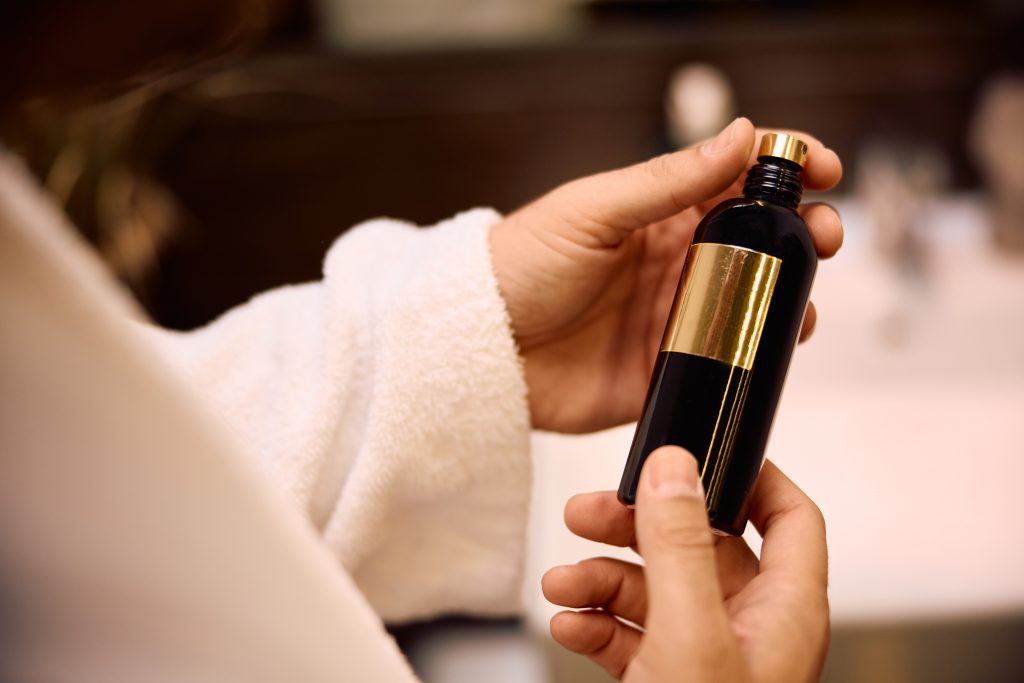 Close up of man using perfume after taking a bath.