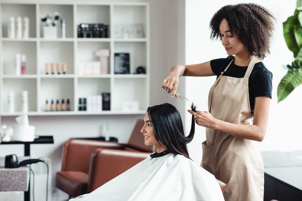 New hairstyle, new life. Young woman enjoying haircut at beauty salon, empty space.