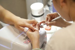 Nail technician performing a manicure for a client at a nail salon